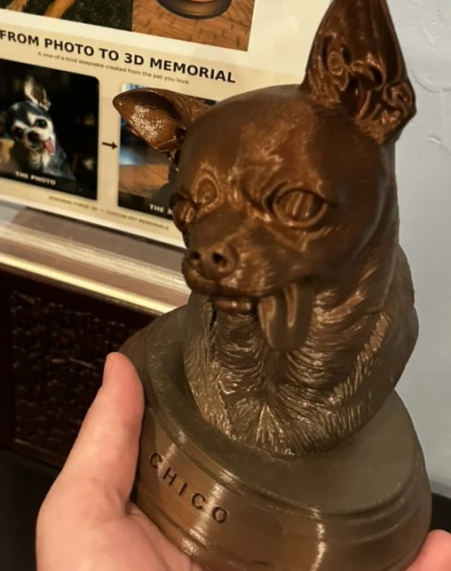 A custom 3D bust of a Chihuahua named Chico, held in a hand